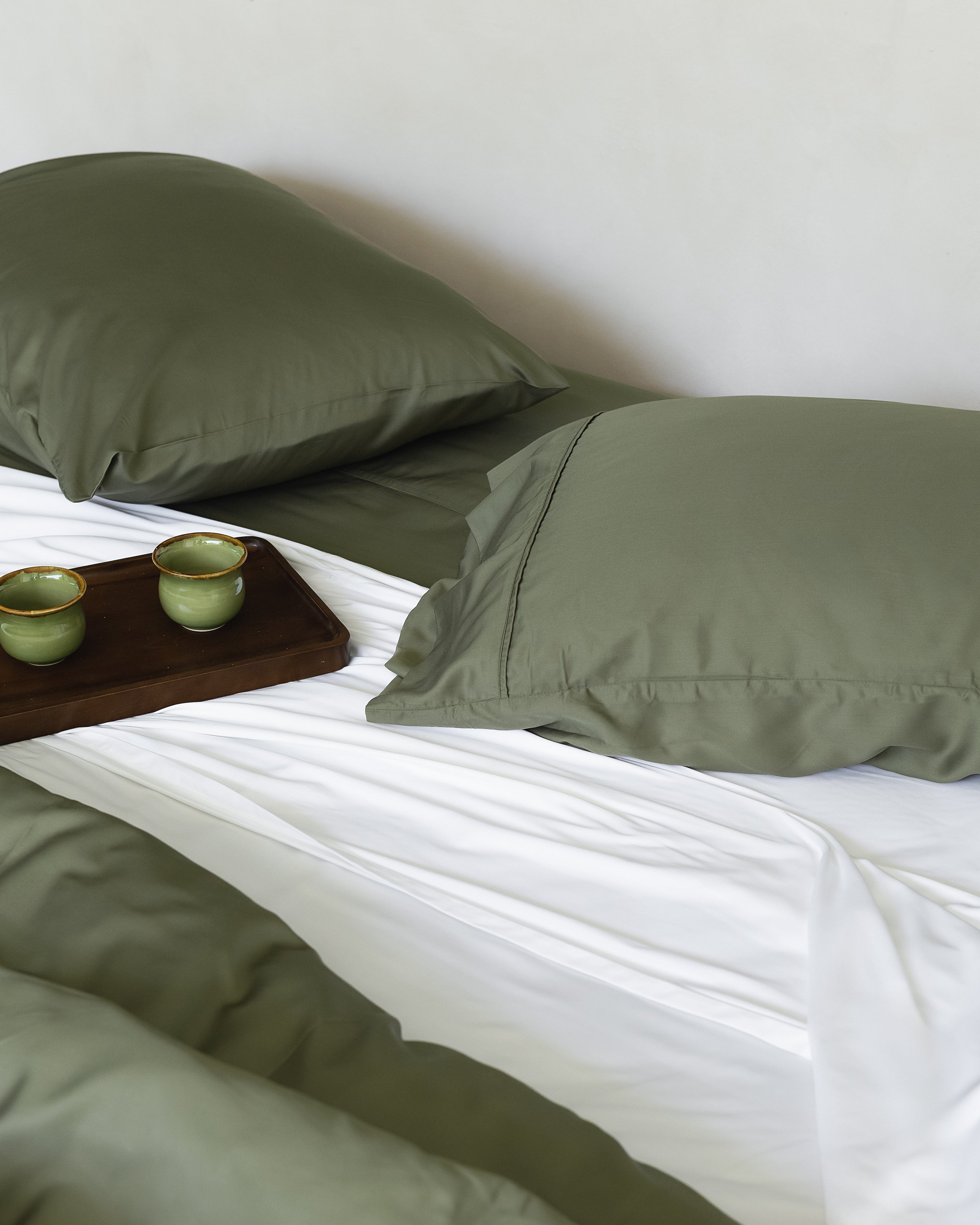 Bali Forest Pillowcases on bed with white wall background