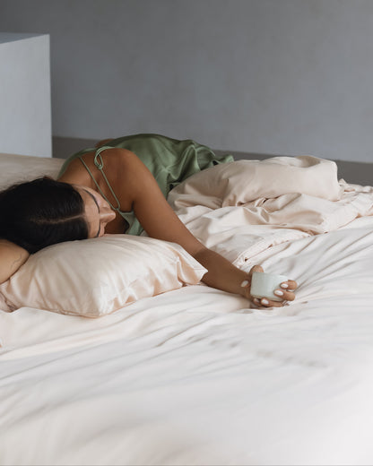 Woman lying on bed with Waikiki Shore pillowcases and bedding