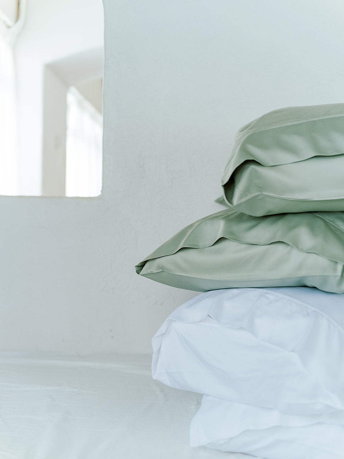 French Sage pillowcase set on a bed with white pillows