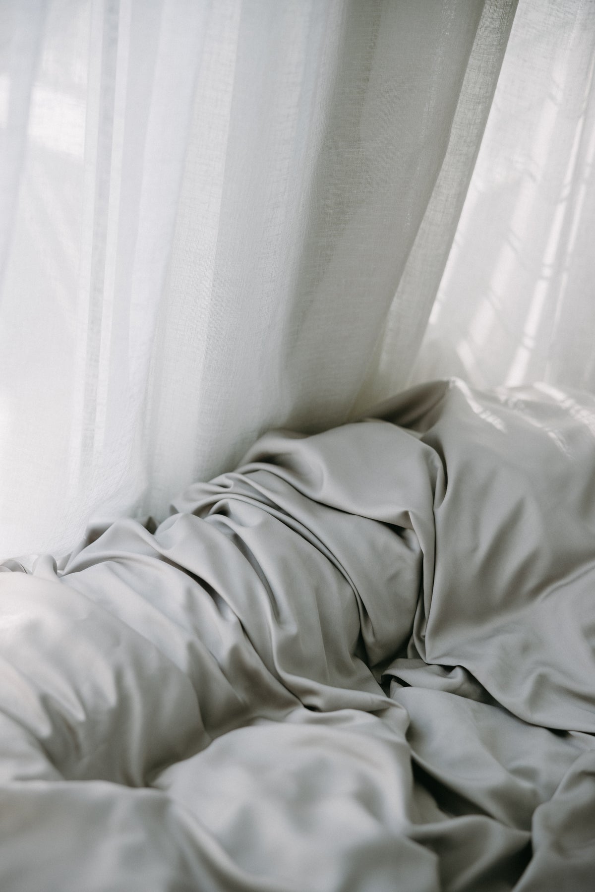 Paris Shimmer bedding on a bed with white curtains in the background